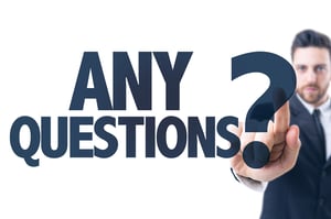 Business man pointing the text: Any Questions?